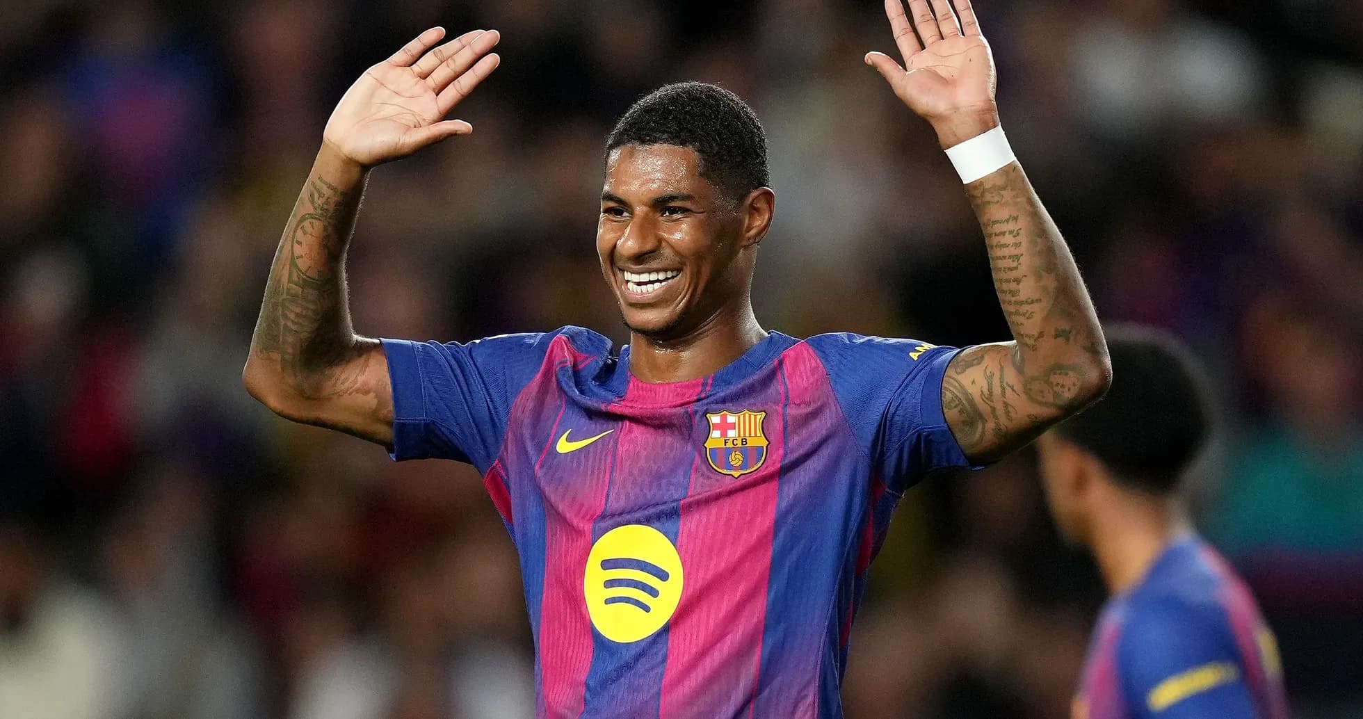 Player celebrating with raised hands in Barcelona jersey