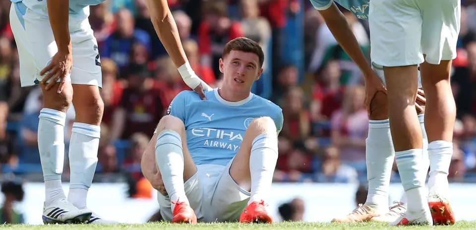 Player sitting on field with teammates nearby
