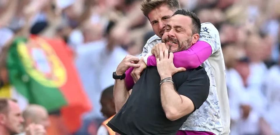 Two coaches celebrating in crowd during match
