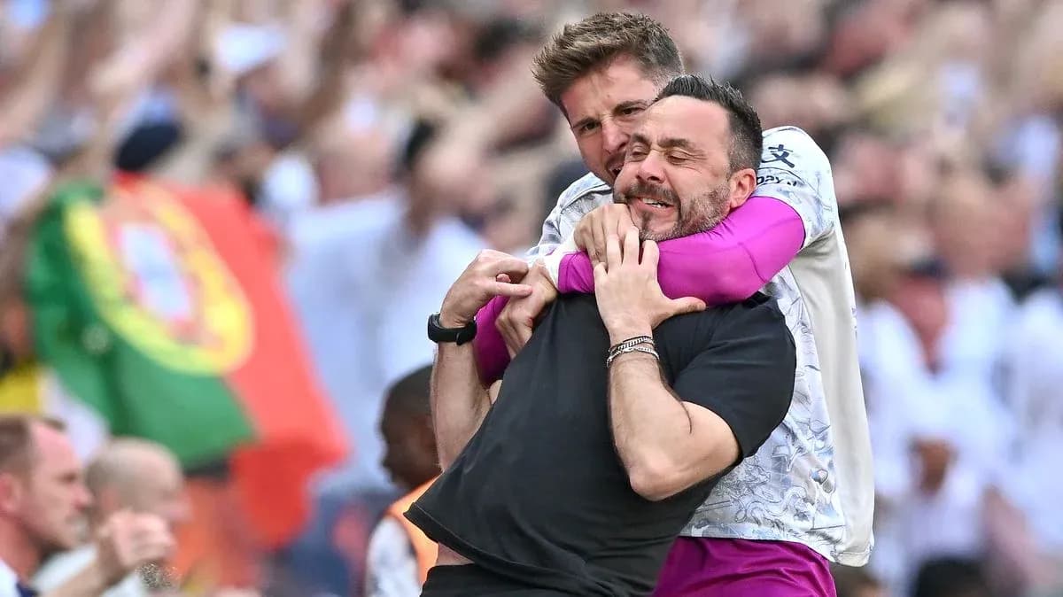 Two coaches celebrating in crowd during match
