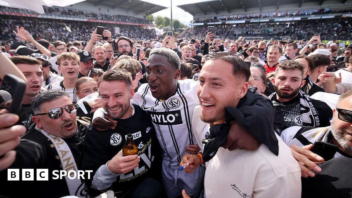 Fans celebrating with players on the pitch
