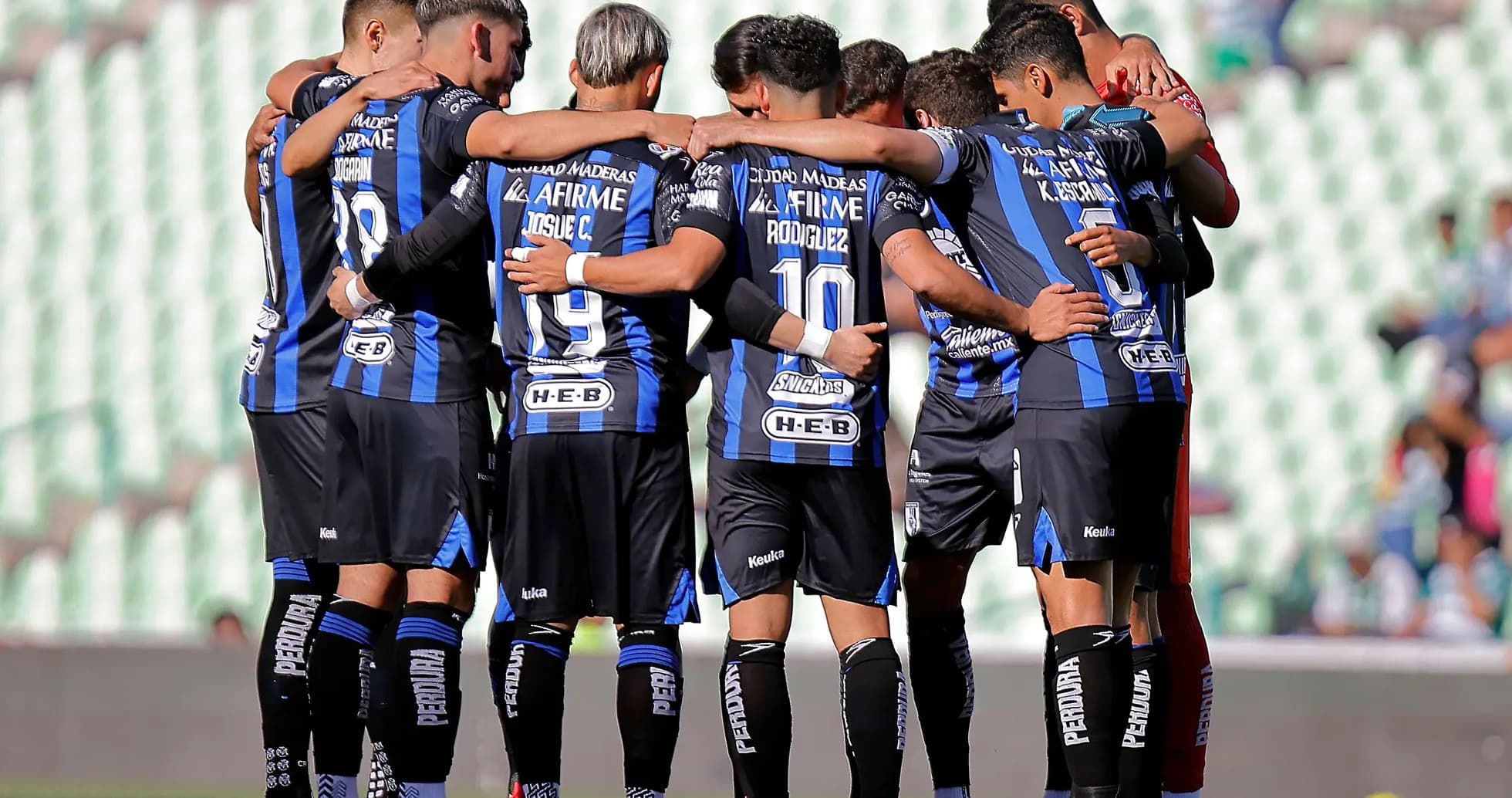 Club Queretaro players huddling before the match