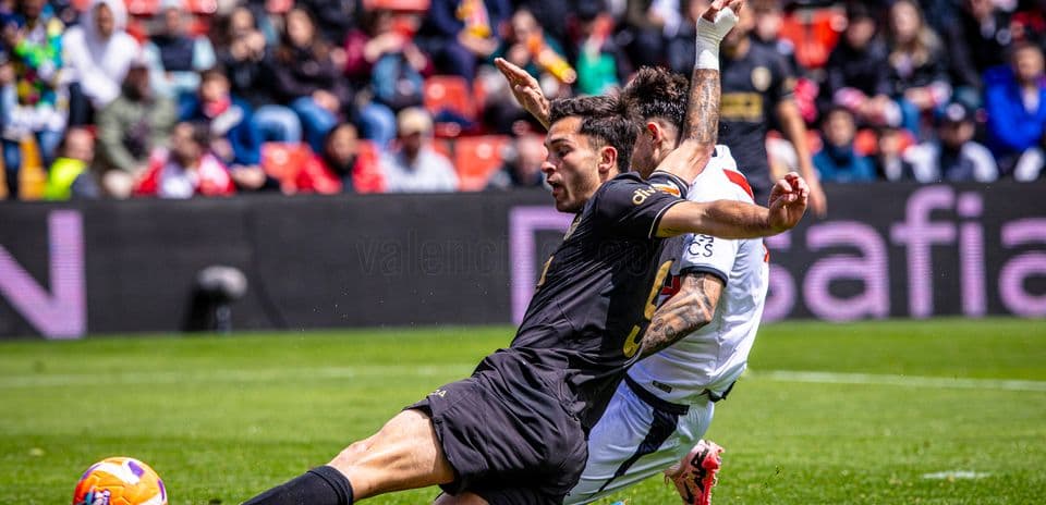 Valencia player tackling Rayo Vallecano opponent
