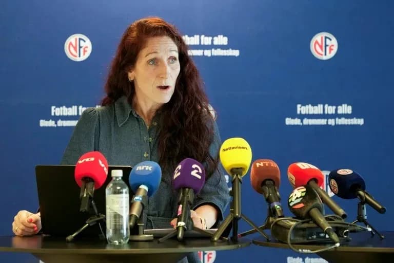 Speaker at press conference with microphones displayed