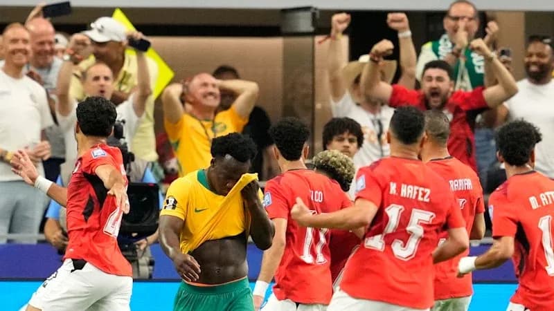 Players celebrating a goal with fans in background