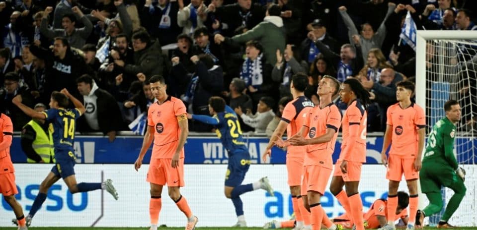 Players in orange jerseys reacting to crowd celebration