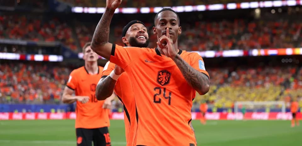 Players celebrating a goal during match in orange jerseys