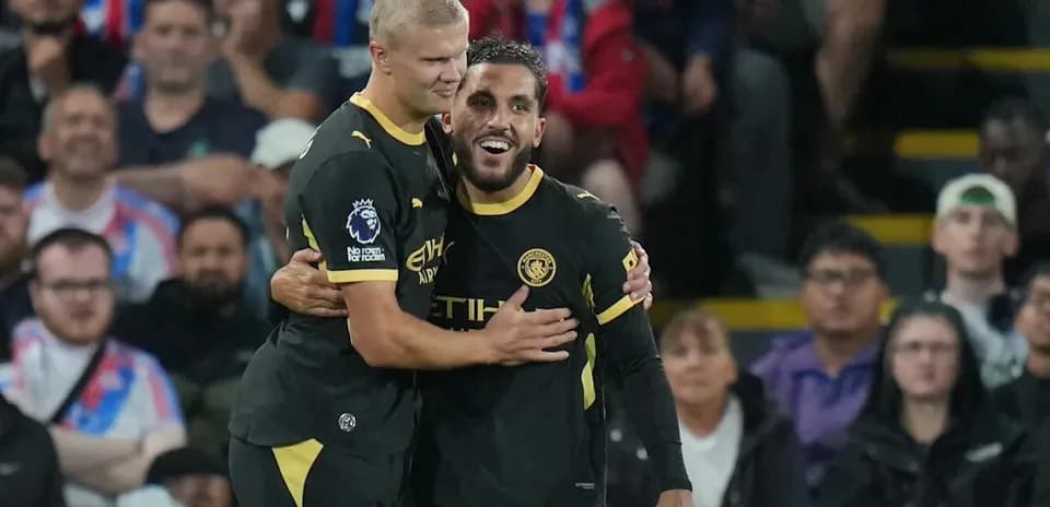 Two players celebrating together on the pitch
