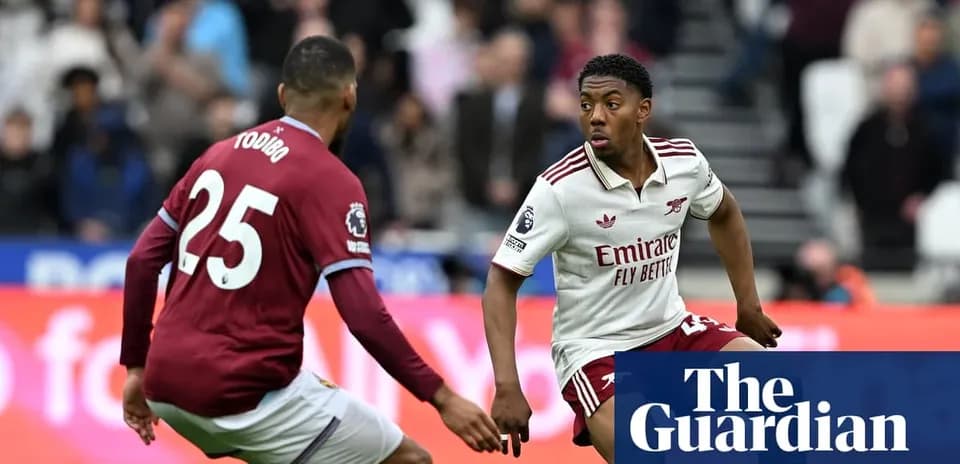 Player in Arsenal kit dribbling past opponent during match