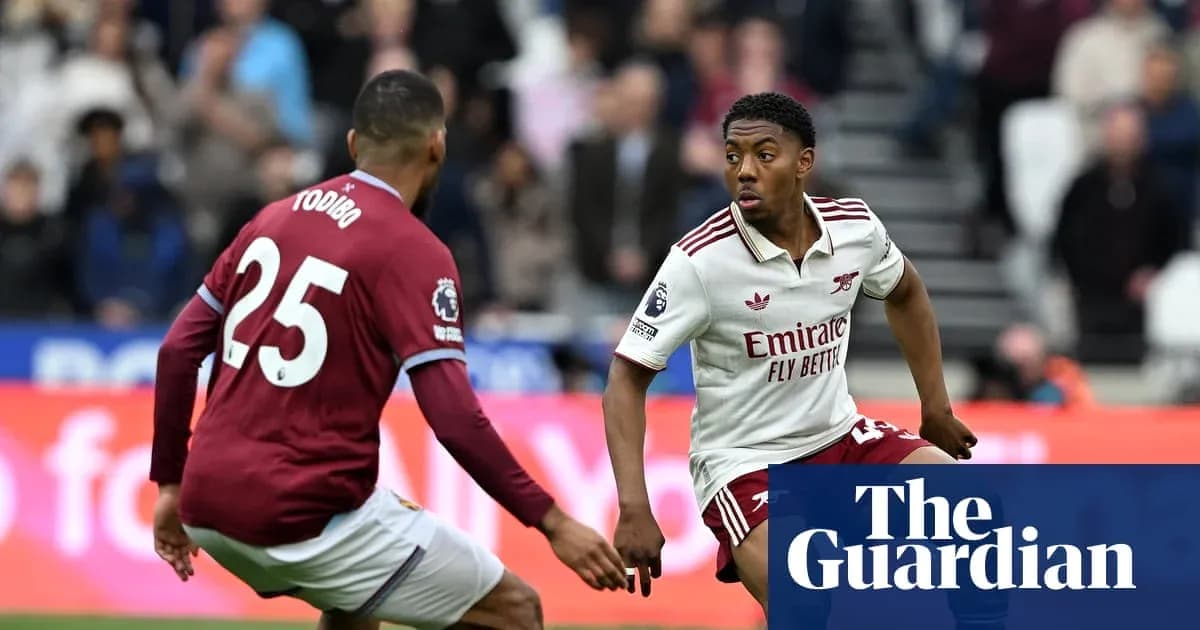 Player in Arsenal kit dribbling past opponent during match