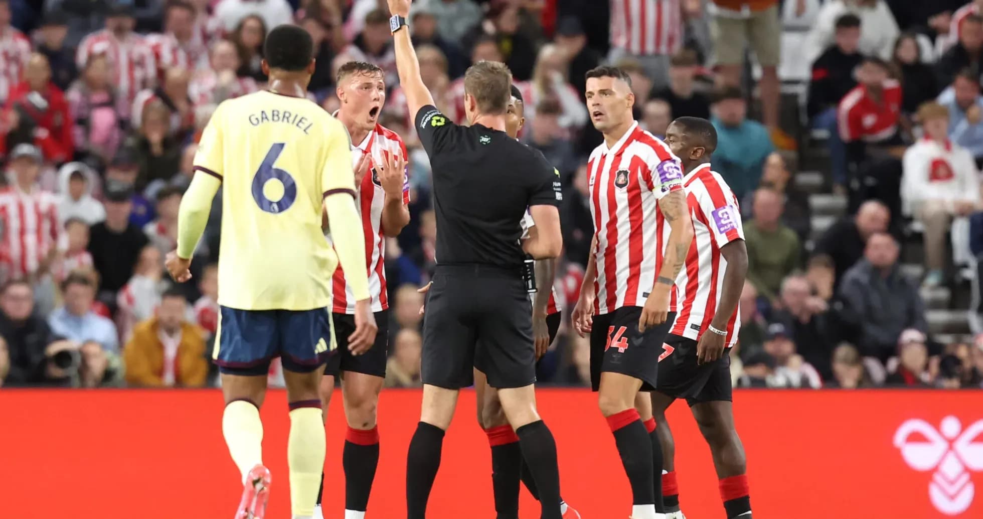 Referee shows yellow card during Sunderland vs Arsenal