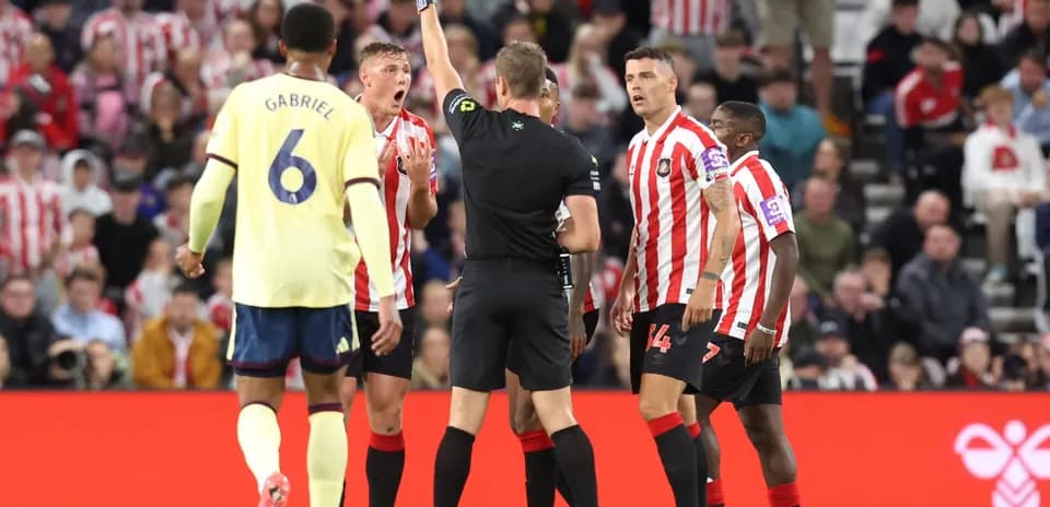 Referee shows yellow card during Sunderland vs Arsenal