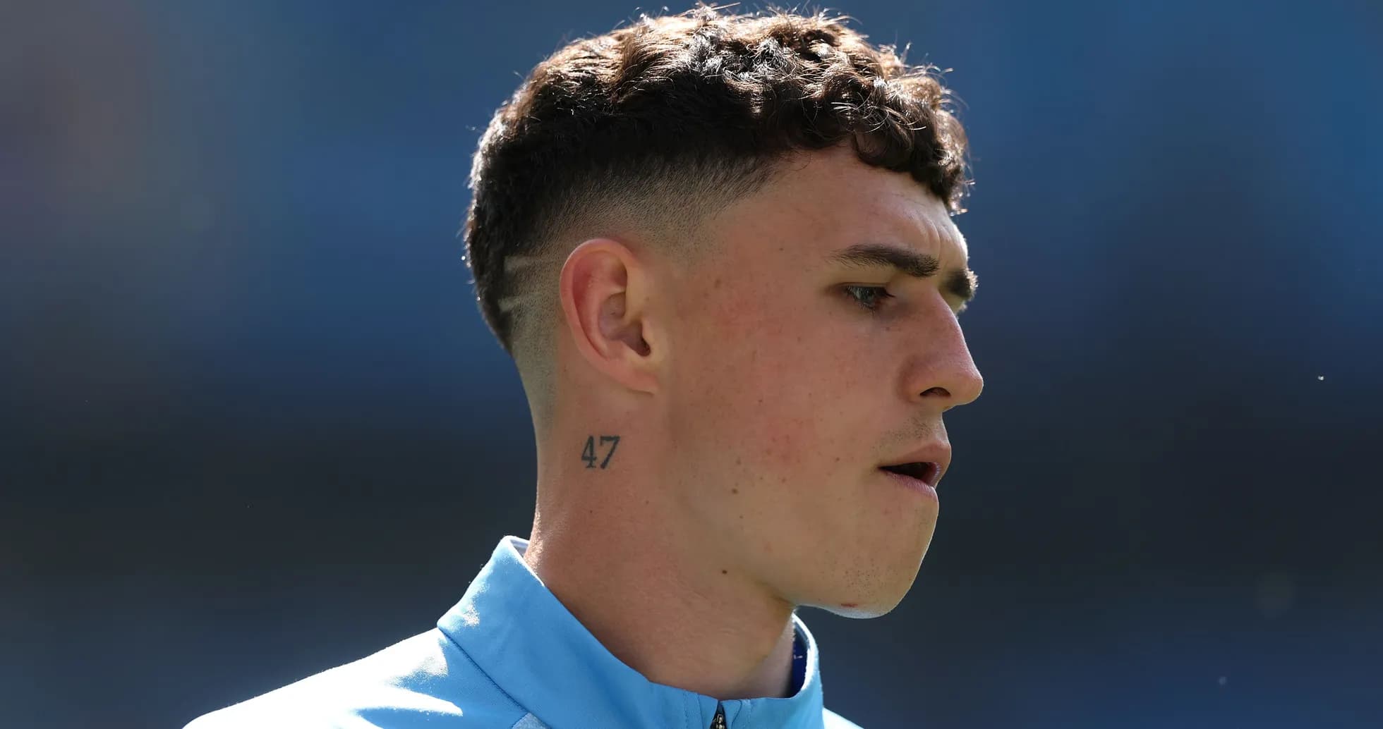 Player with short hair wearing blue training jacket