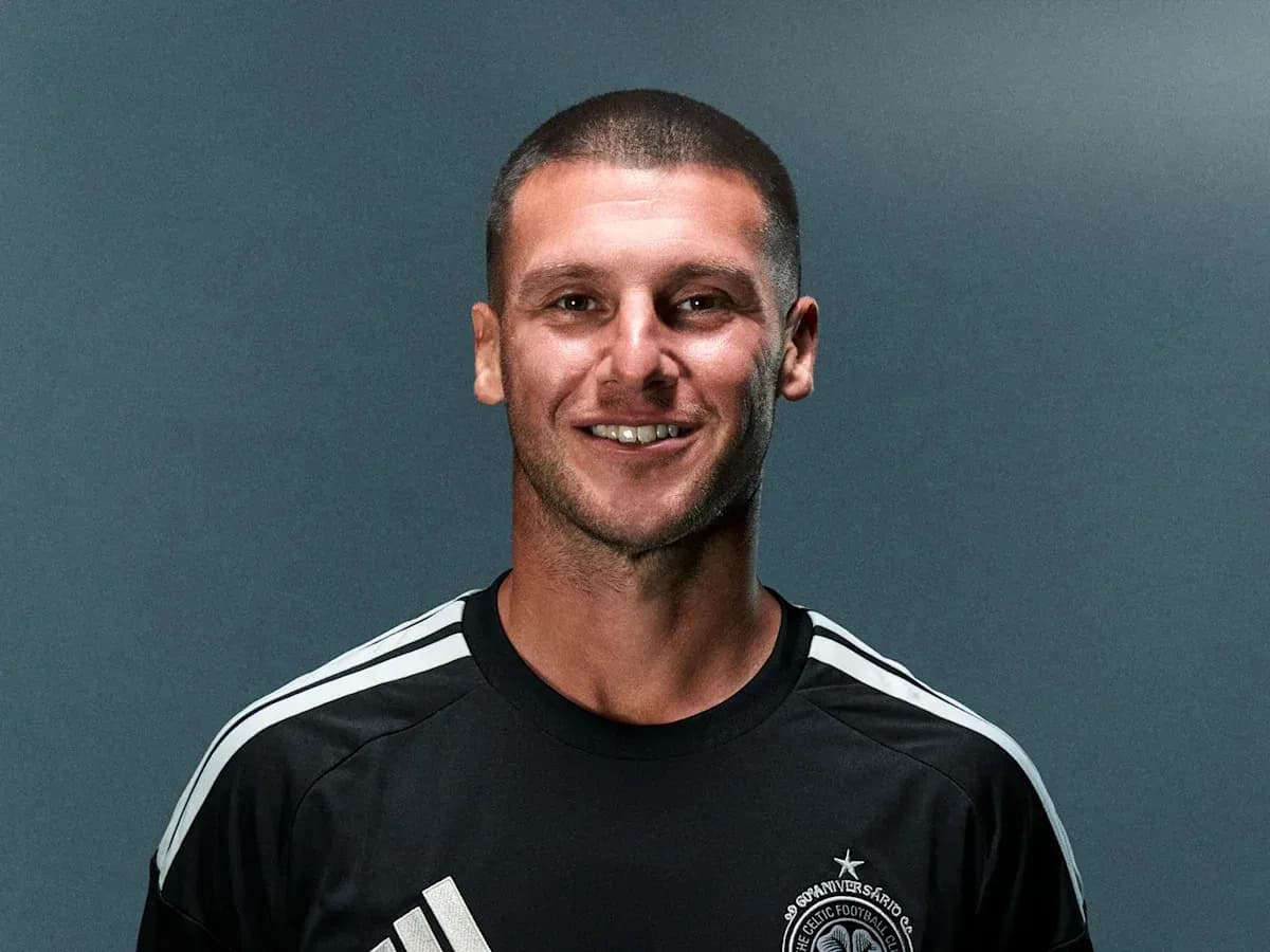 Player in black kit smiling for photo