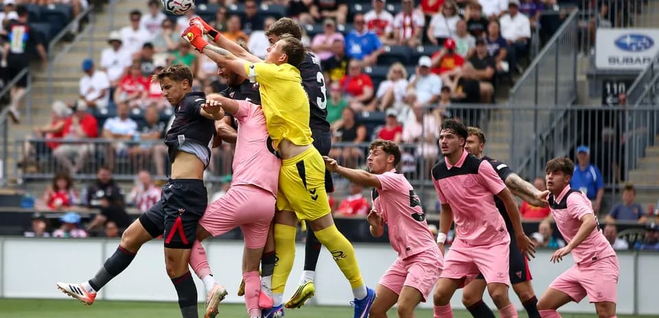 Goalkeeper jumping to catch the ball amid players