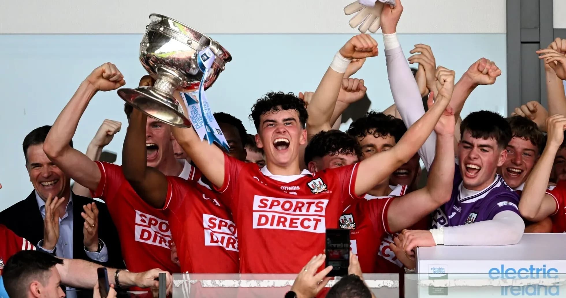 Team celebrating victory with trophy in hand