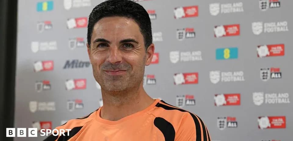 Manager smiling during press conference with backdrop