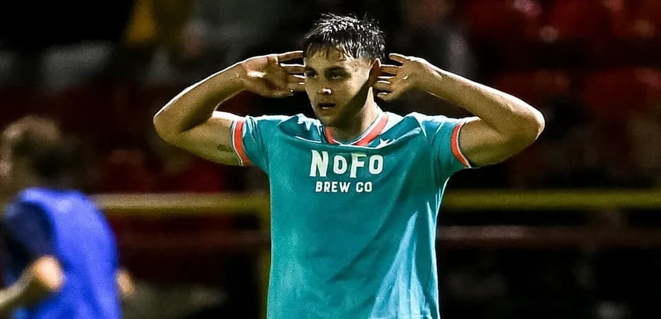 Player celebrating with hands to ears after scoring