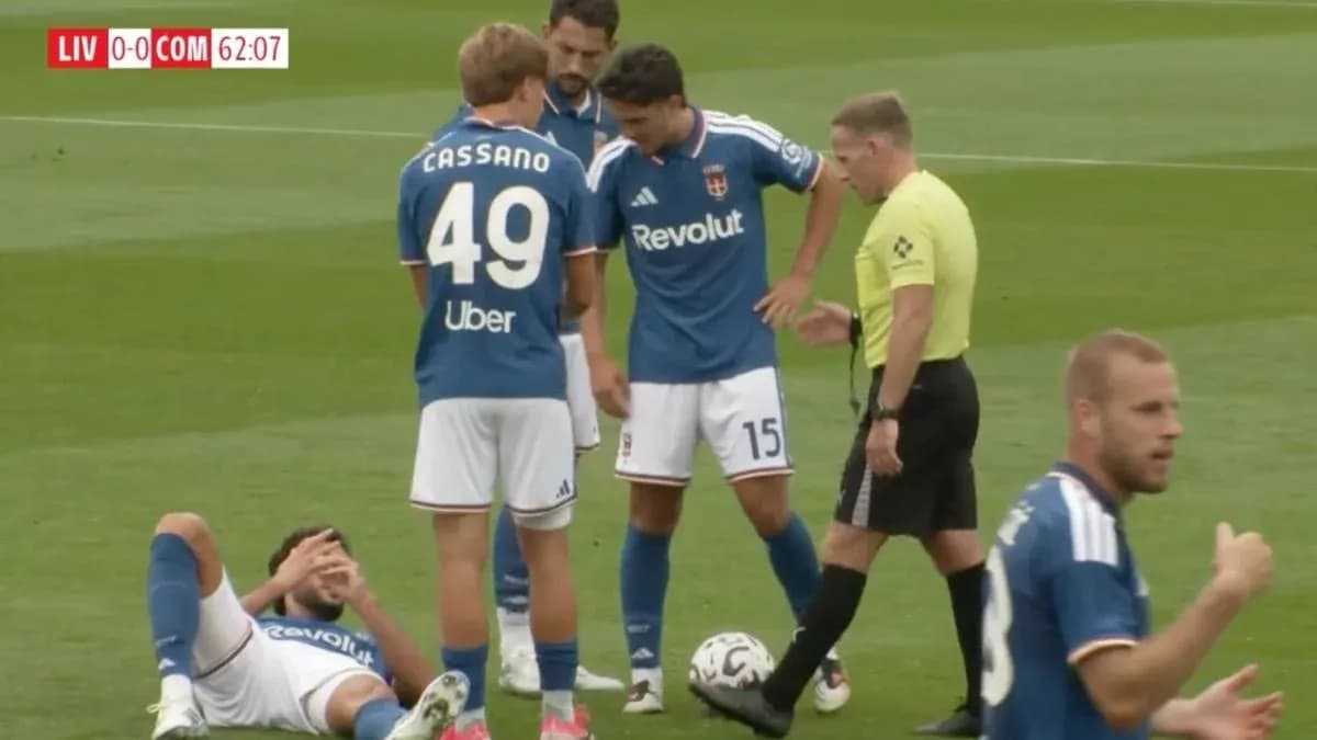 Players and referee discussing an injury on field