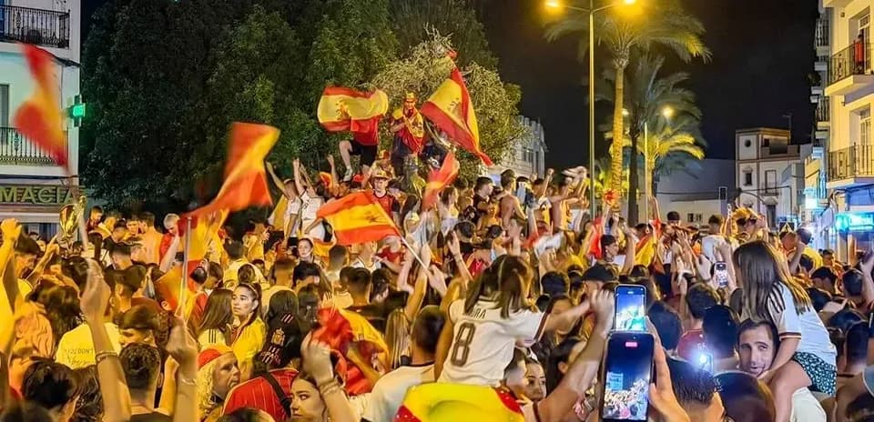 Crowd celebrating with flags in night street