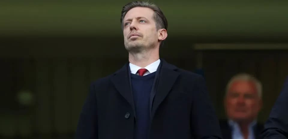 Man in a suit observing from the stands