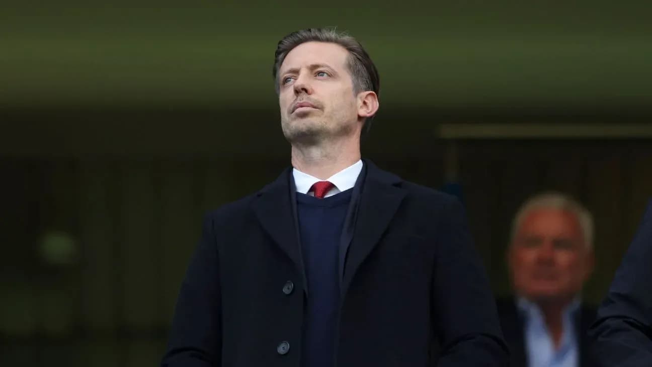 Man in a suit observing from the stands