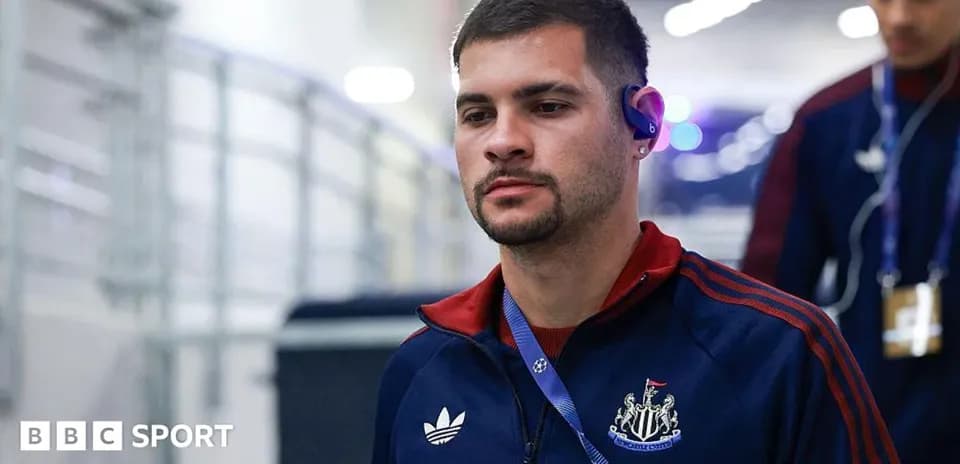 Player entering stadium wearing team tracksuit