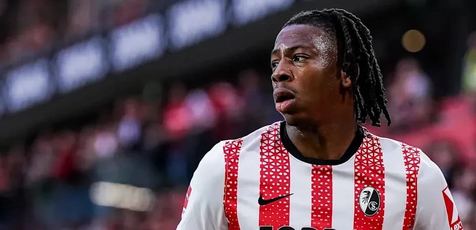Player wearing red and white striped jersey on pitch