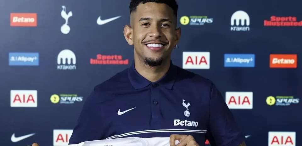 Player holding Tottenham Hotspur shirt at press conference