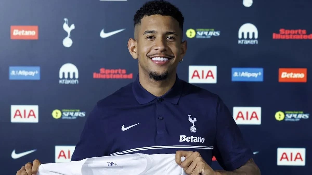 Player holding Tottenham Hotspur shirt at press conference