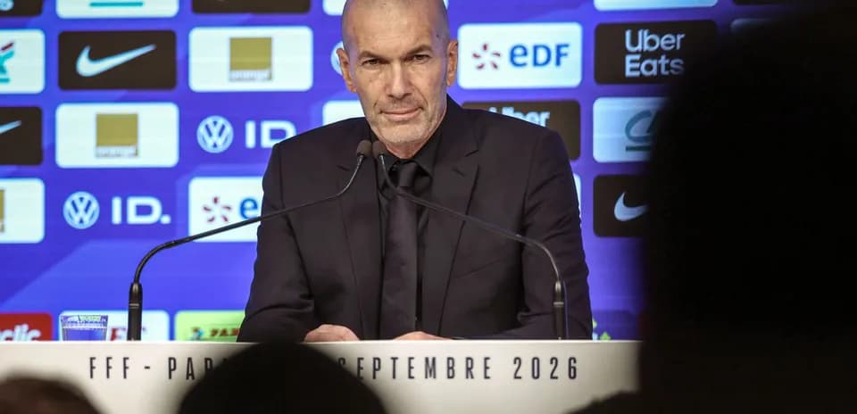 Manager speaking at press conference with logos backdrop