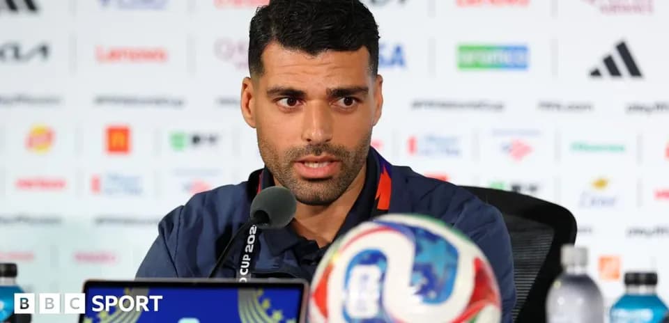 Player speaking at press conference with soccer ball