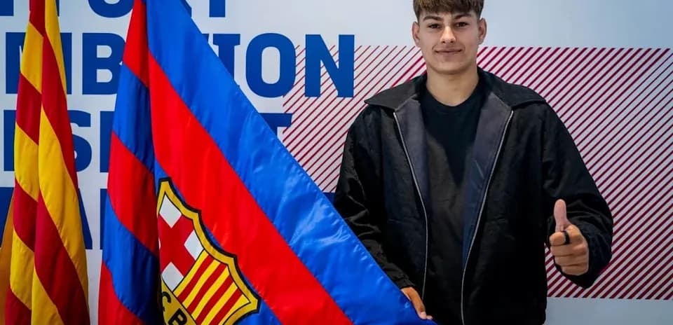 Player posing with FC Barcelona flag and logo