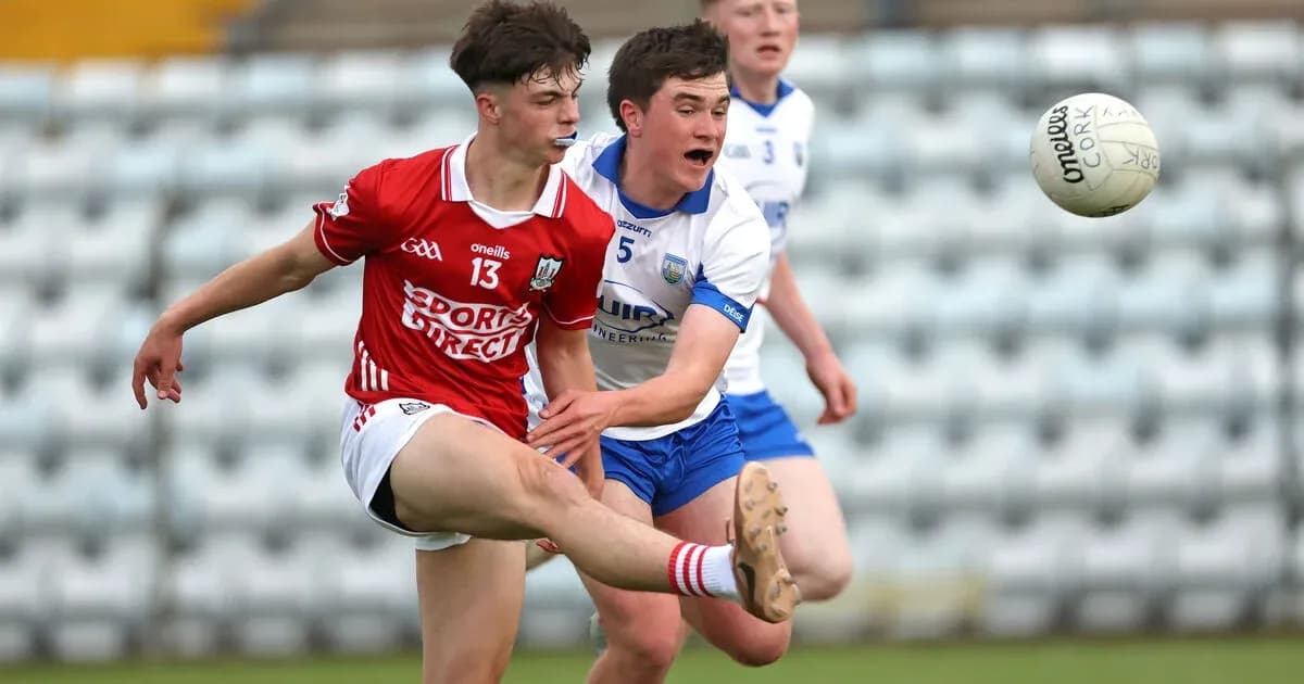 Player kicking a ball while being challenged by opponent