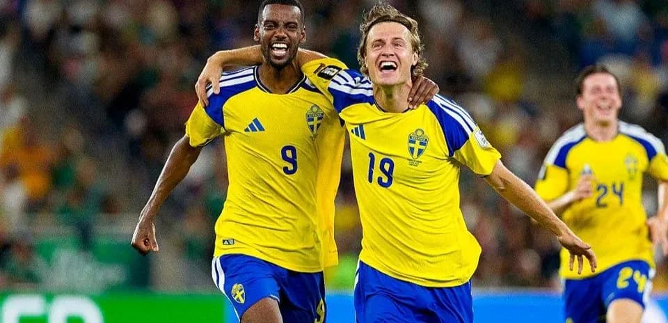 Two Swedish players celebrating a goal during match