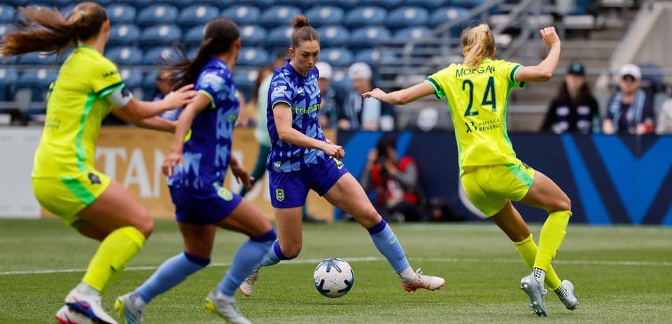 Seattle Reign FC player dribbling past defenders