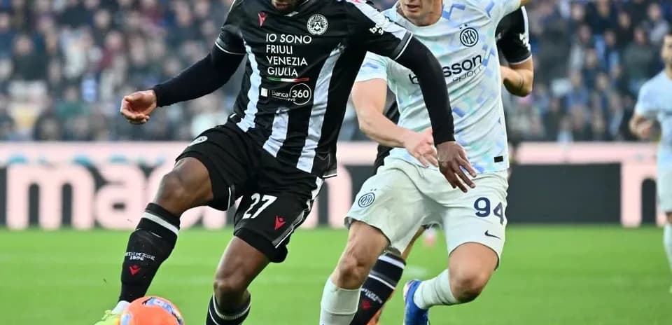Inter player challenging Udinese opponent for the ball