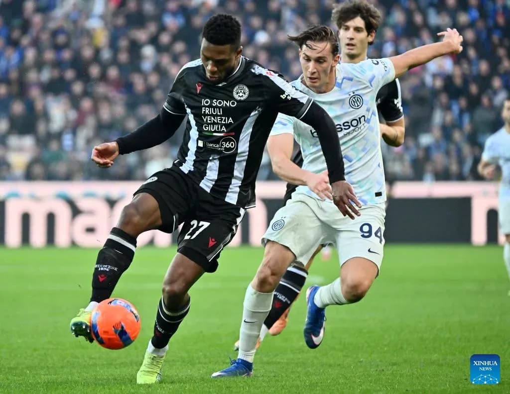 Inter player challenging Udinese opponent for the ball