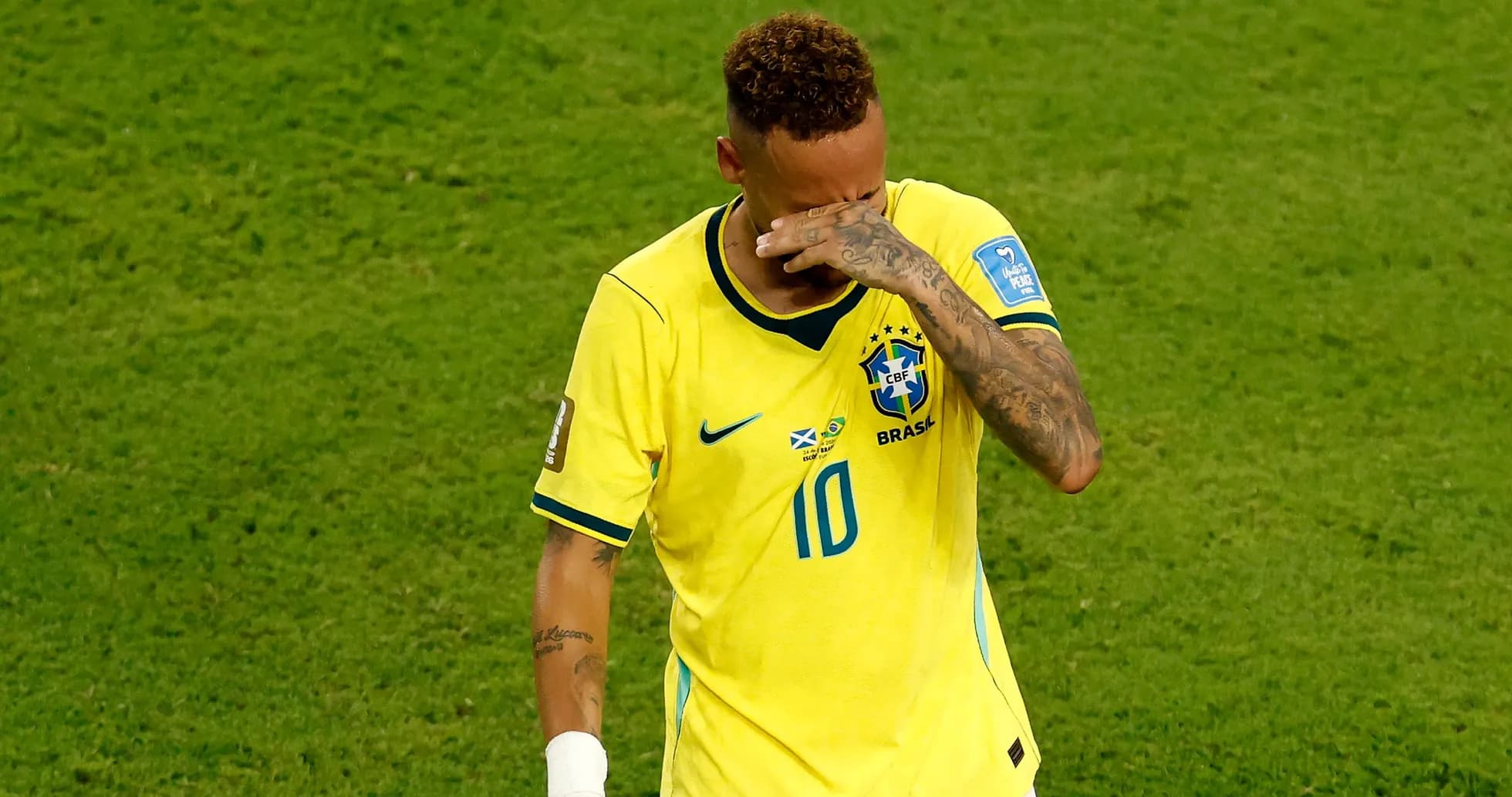 Player in Brazil jersey wiping face during match