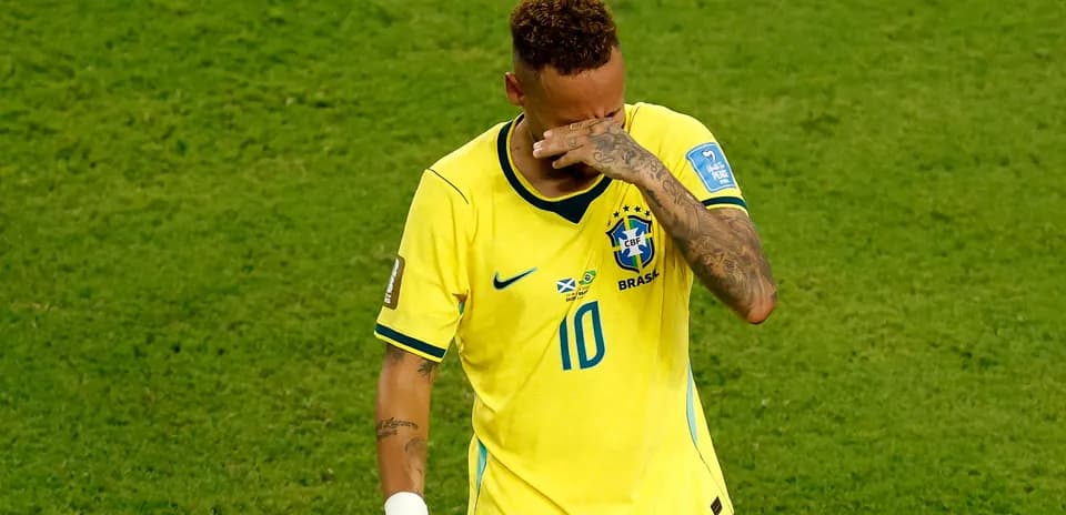 Player in Brazil jersey wiping face during match