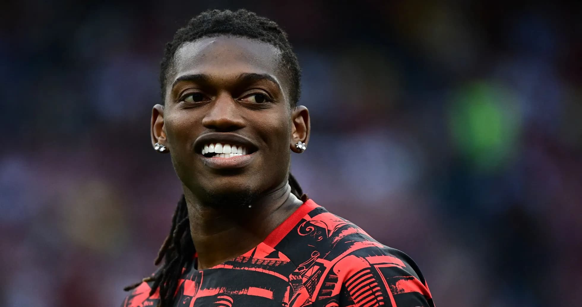 Player smiling while wearing a red patterned jersey