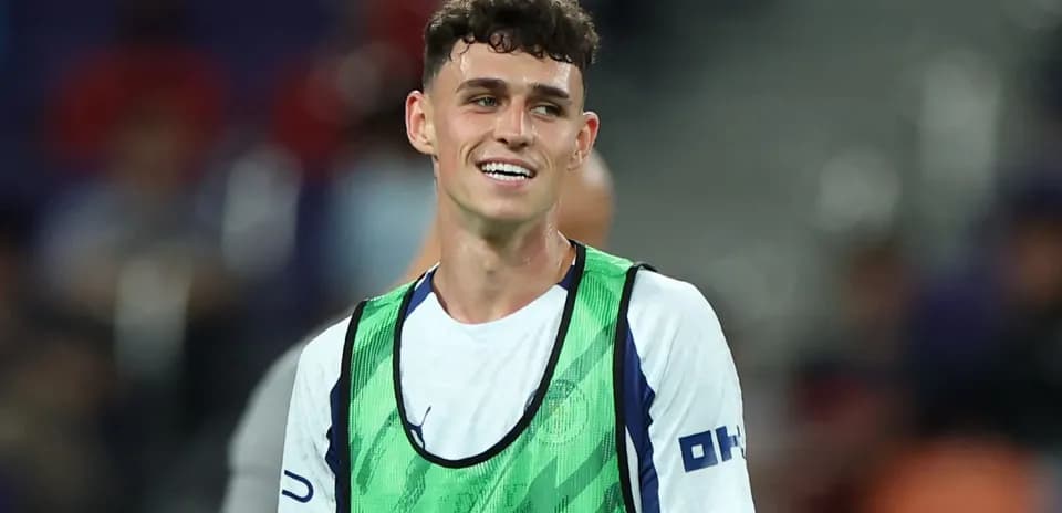 Player smiling in training vest on pitch