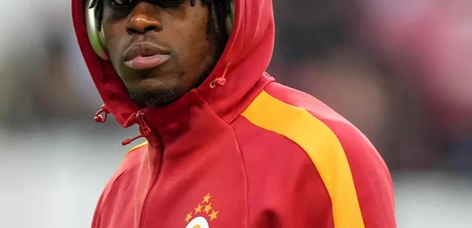 Player in red and yellow jacket during warm-up