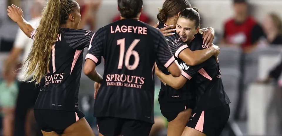 Players celebrating a goal during NWSL match