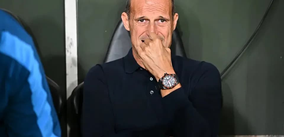 Coach sitting on bench during match, deep in thought