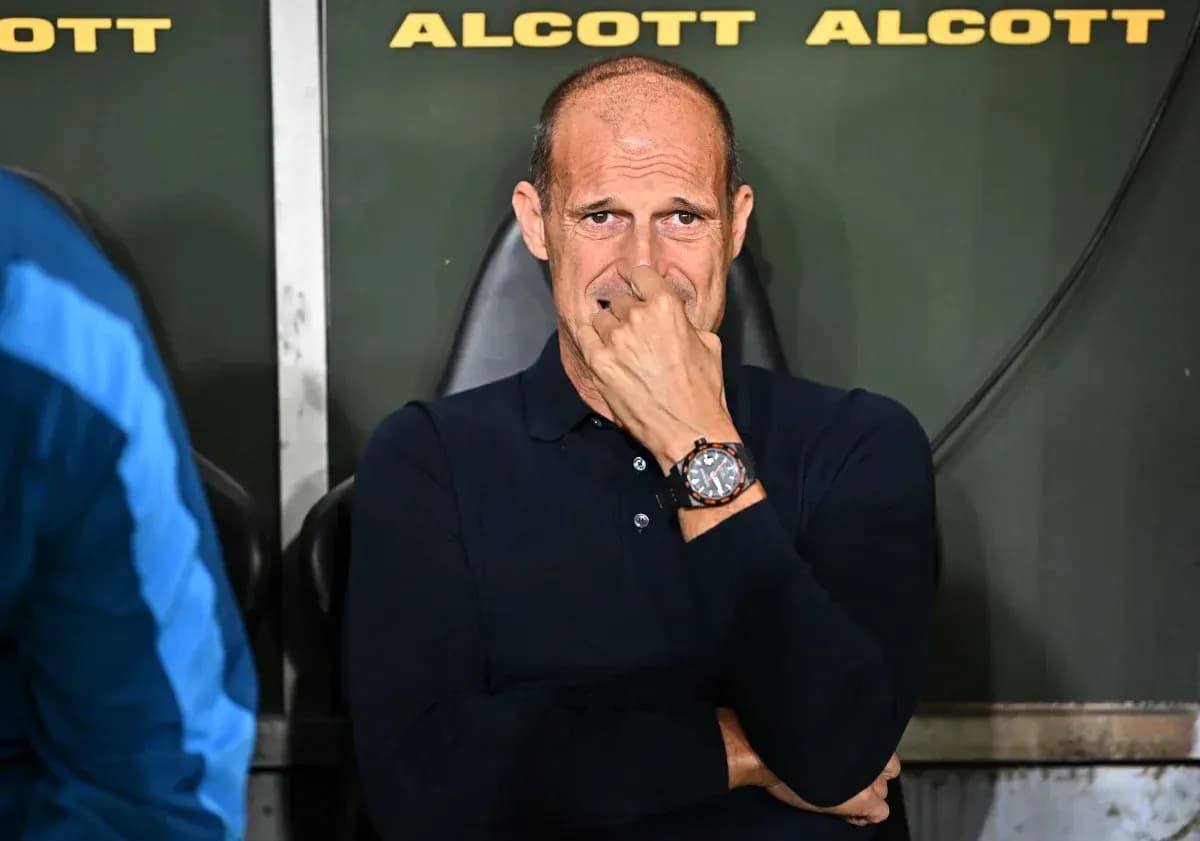Coach sitting on bench during match, deep in thought