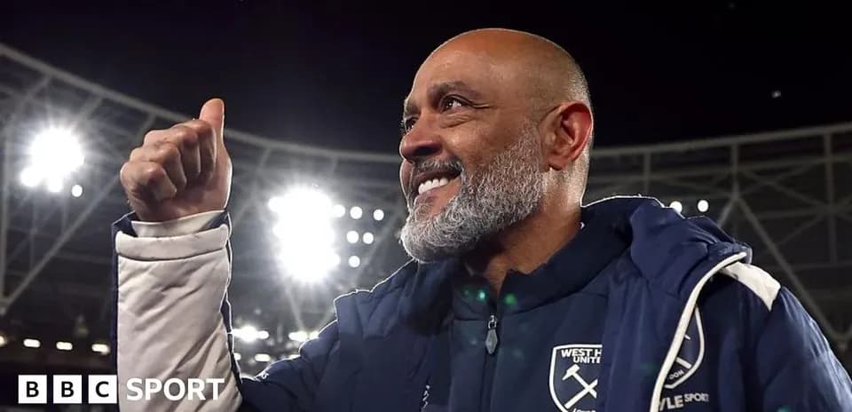 Manager celebrating with thumbs up at stadium