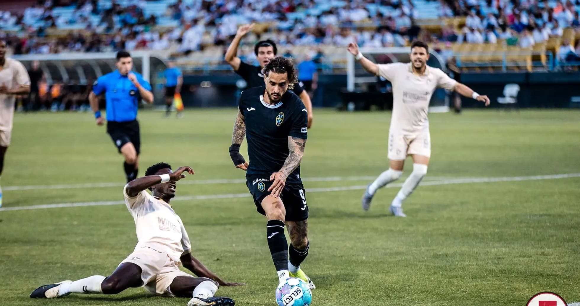 Las Vegas Lights player dribbling past FC Tulsa opponent