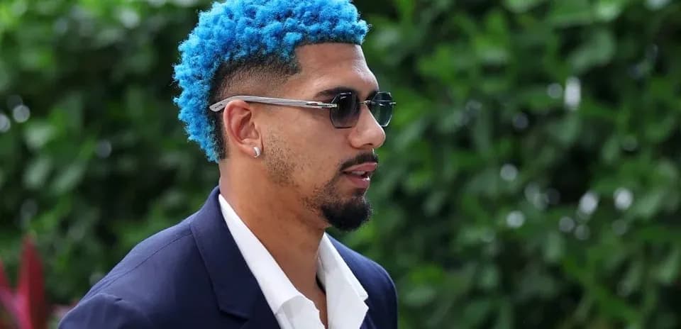 Man with blue hair and sunglasses walking outdoors