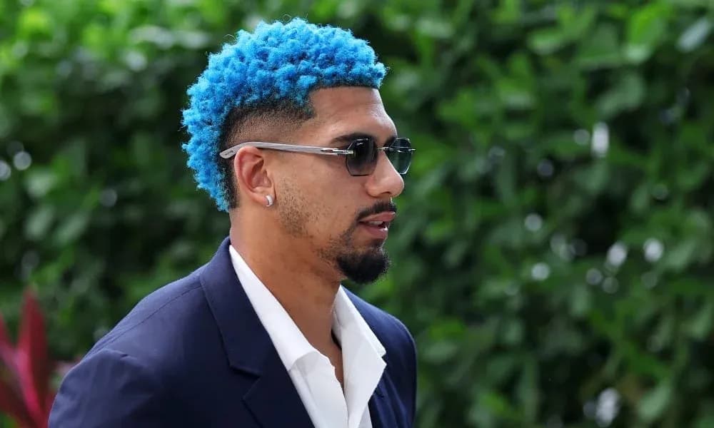 Man with blue hair and sunglasses walking outdoors